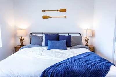 a bed with blue pillows and a baseball bat on the wall at Revy's Stellar Retreat in Revelstoke