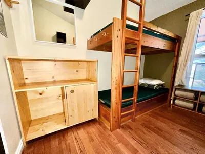 a bunk bed in a room with a ladder at Canmore Alpine Hostel - Alpine Club of Canada in Canmore