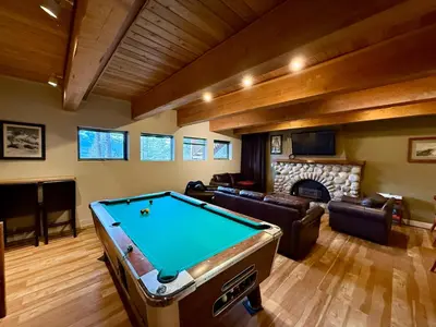 a living room with a pool table and a fireplace at Canmore Alpine Hostel - Alpine Club of Canada in Canmore