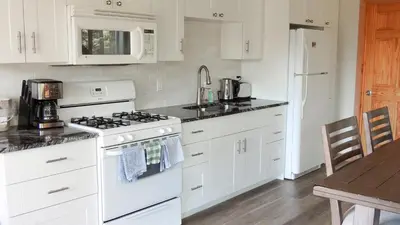 a white kitchen with a stove and a sink at Canmore Alpine Hostel - Alpine Club of Canada in Canmore