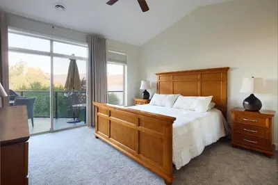 a bedroom with a bed and a large window at Lakeside Luxe Haven in West Kelowna