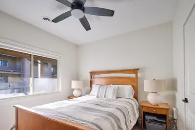 a bedroom with a bed with a ceiling fan at Lakeside Luxe Haven in West Kelowna