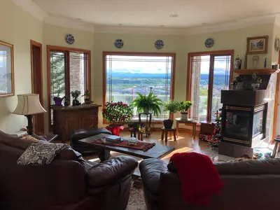a living room with couches and a fireplace at Rocky Mountain View Bed & Breakfast in Cochrane
