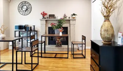 a living room with a table and chairs and a fireplace at Vivi's Home in Vancouver
