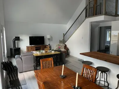 a living room with a couch and a table with chairs at Stunning 5-bed Retreat in Sunshine Valley in Sunshine Valley