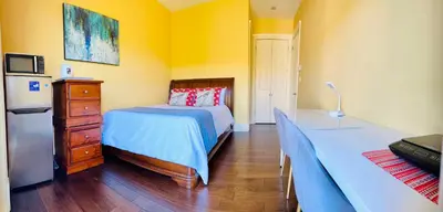 a bedroom with a bed and a dresser and a refrigerator at Quiet Room in Richmond in Richmond