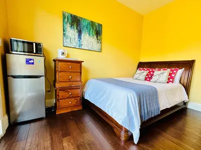 a bedroom with a bed with a microwave and a refrigerator at Quiet Room in Richmond in Richmond
