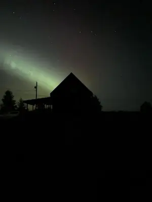 a house with a green light in the night sky at Sunrise Cabin- The Loft - secluded Beach front guest house in Sandspit