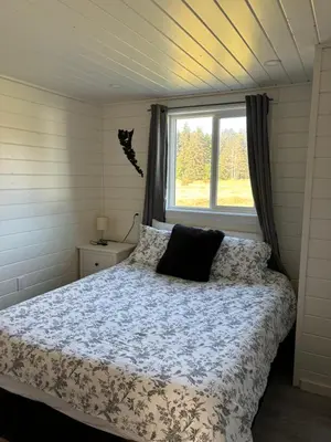 a bedroom with a bed and a window at Sunrise Cabin- The Loft - secluded Beach front guest house in Sandspit