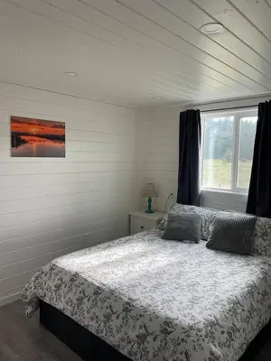 a bedroom with a bed and a window at Sunrise Cabin- The Loft - secluded Beach front guest house in Sandspit