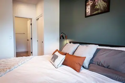 a bedroom with a large white bed with pillows at The Three Bear Penthouse - with Hot Tub in Revelstoke