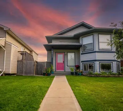 a house with a pink door in a yard at Pink door-ed wonder in Grande Prairie