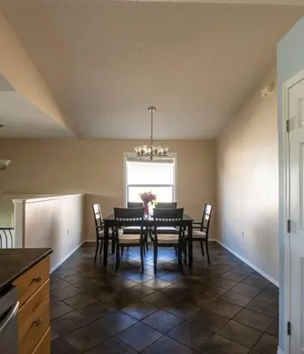 a dining room with a table and chairs and a window at Pink door-ed wonder in Grande Prairie