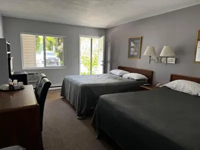 a hotel room with two beds and a window at Clearwater Country Inn in Clearwater