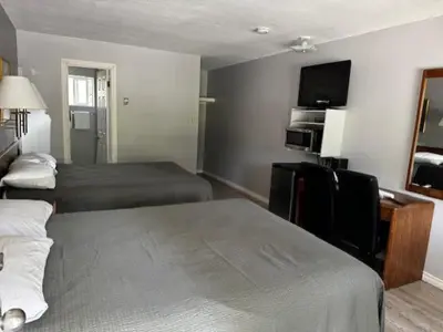 a hotel room with two beds and a flat screen tv at Clearwater Country Inn in Clearwater