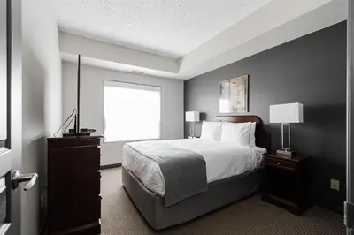 a bedroom with a large bed and a window at Premier Residence - Fort McMurray in Fort McMurray