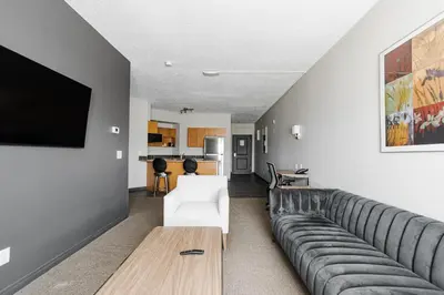 a living room with a couch and a tv at Premier Residence - Fort McMurray in Fort McMurray