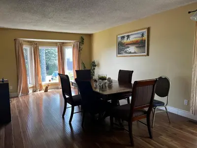 a dining room with a wooden table and chairs at Beautiful room close Airport! in Calgary