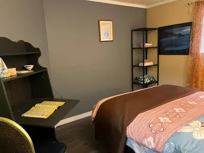 a bedroom with a bed and a table and a shelf at Beautiful room close Airport! in Calgary