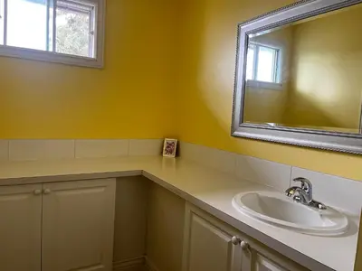 a bathroom with a sink and a mirror at Beautiful room close Airport! in Calgary