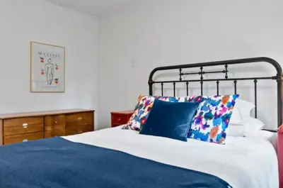 a bedroom with a bed with blue sheets and pillows at Mid-Century Modern Dream Retreat in West Kelowna
