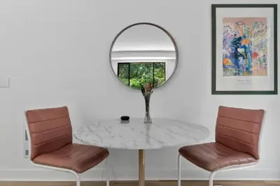 a round table with two chairs and a mirror at Mid-Century Modern Dream Retreat in West Kelowna