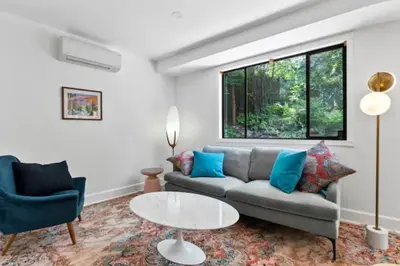 a living room with a couch and a table at Mid-Century Modern Dream Retreat in West Kelowna