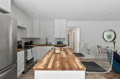 a kitchen with a wooden table and chairs in it at Mid-Century Modern Dream Retreat in West Kelowna