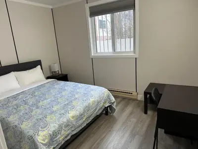 a bedroom with a bed and a window and a desk at City Centre Motel II in Hope