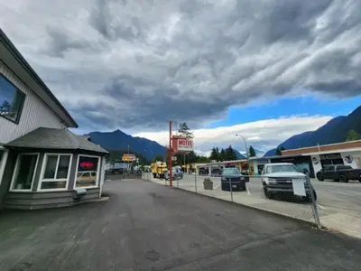 an empty parking lot in a small town with mountains at City Centre Motel II in Hope