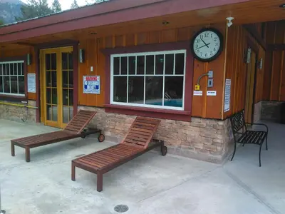 two benches in front of a building with a clock at Fairmont Mountain Bungalows in Fairmont Hot Springs