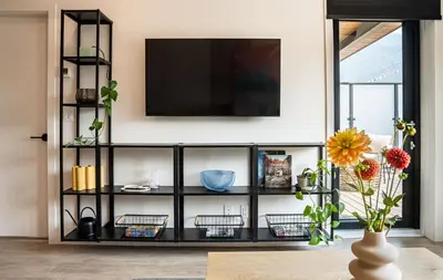 a black shelving unit with a television on a wall at Galena by Revelstoke Vacations in Revelstoke