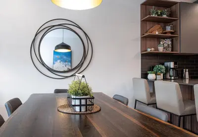 a dining room with a wooden table and a mirror at Revylation by Revelstoke Vacations in Revelstoke