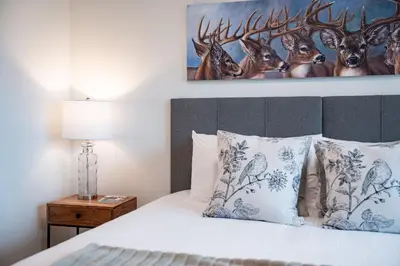 a bedroom with a bed with a painting on the wall at Revylation by Revelstoke Vacations in Revelstoke