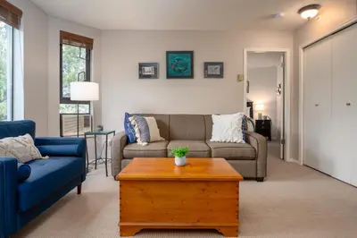 a living room with a couch and a table at 1BR in Marquise, Close to Ski Hill, Pool, Sauna, Hot Tub, Fitness Suite, Fireplace in Whistler