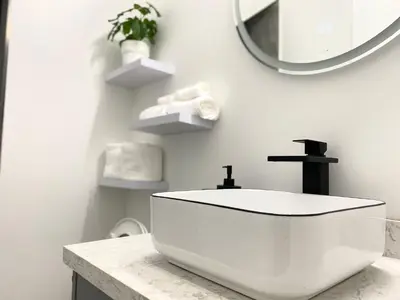 a white bathroom with a sink and a mirror at Modern and New house near PNE with Big Garden and Free Parking in Vancouver