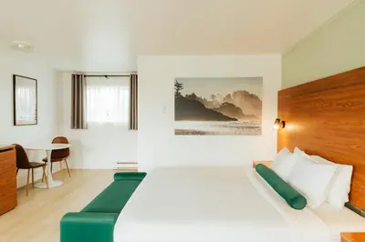 a hotel room with a bed and a table at Ucluelet Wildwood Inn in Ucluelet