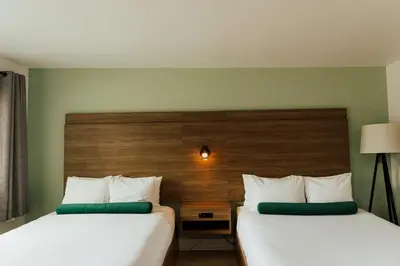 a hotel room with two beds and a headboard at Ucluelet Wildwood Inn in Ucluelet