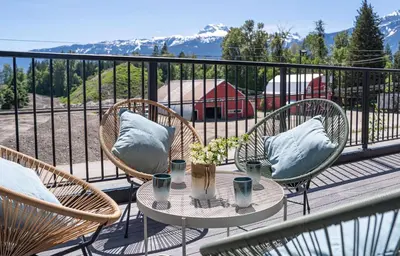 a balcony with chairs and a table with pillows on it at Western Star by Revelstoke Vacations in Revelstoke