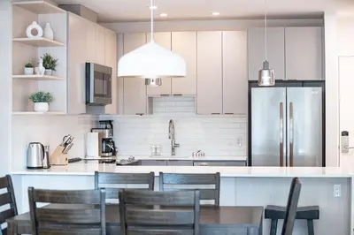 a kitchen with white cabinets and a table and chairs at The Grizzly Basin by Revelstoke Vacations in Revelstoke