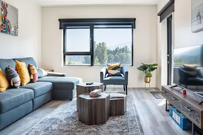 a living room with a couch and a table at Rummy's Adventure Bay by Revelstoke Vacations in Revelstoke