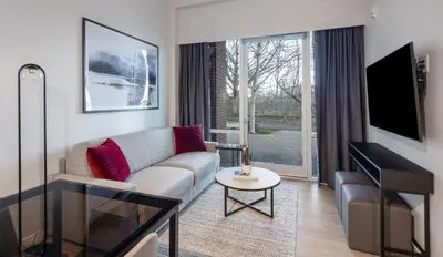 a living room with a couch and a tv at Steveston Waterfront Hotel in Richmond