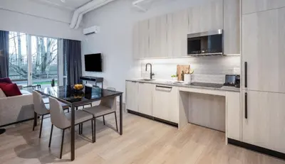 a kitchen with a table and a dining room at Steveston Waterfront Hotel in Richmond