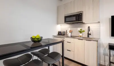 a kitchen with a counter with chairs and a microwave at Steveston Waterfront Hotel in Richmond