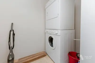 a washer and dryer in a white laundry room at Light N Airy, Pool, Hot Tub, Pets, Ground Floor in Invermere