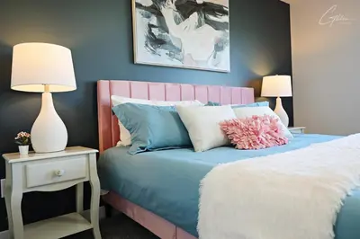 a bedroom with a blue bed with a pink headboard at Beautiful 3 King Beds,Garage,Airport,Disney+ in Edmonton