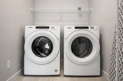 a washing machine and a dryer in a laundry room at Bright & Spacious 3 Beds Luxury Home in SE Calgary in Calgary