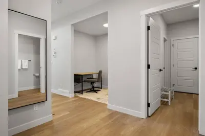 a hallway with a mirror and a desk in a room at Bright & Spacious 3 Beds Luxury Home in SE Calgary in Calgary