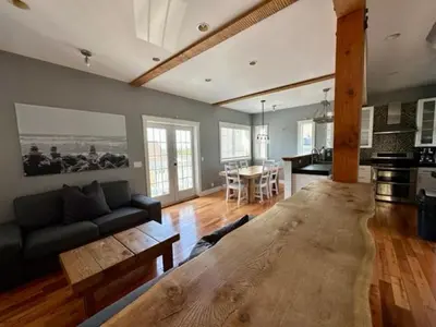a living room with a couch and a wooden table at Surfs Inn Guesthouse & Cottages in Ucluelet