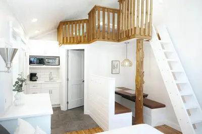 a tiny house with a staircase and a kitchen at Surfs Inn Guesthouse & Cottages in Ucluelet